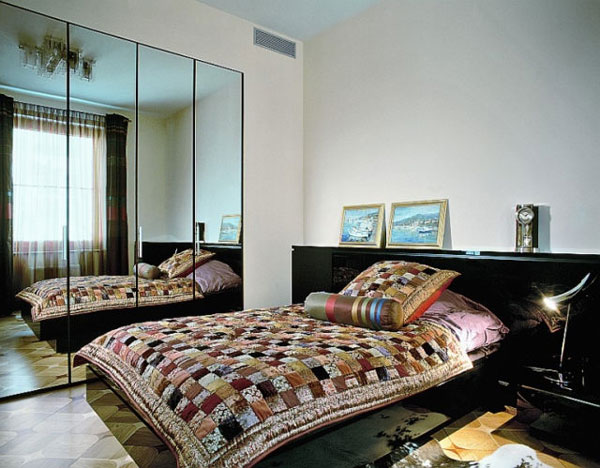 Яркий плед и зеркальный шкаф в небольшой спальне