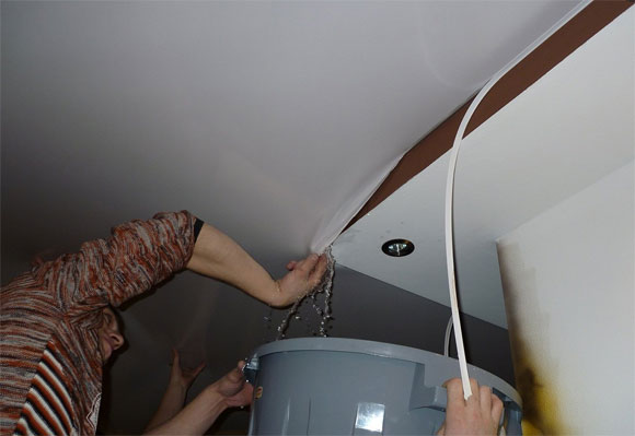 слить воду с натяжного потолка